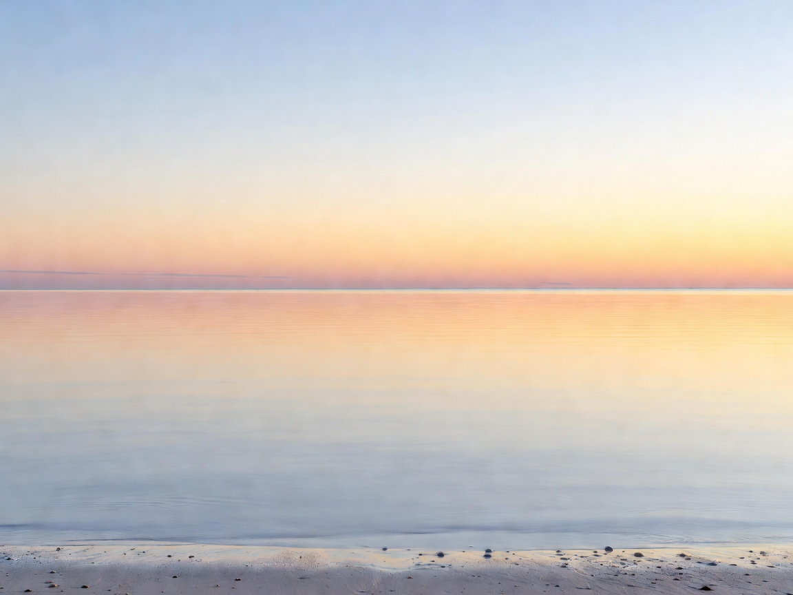Calm sea and open horizon viewed from a quiet shoreline on a bright morning