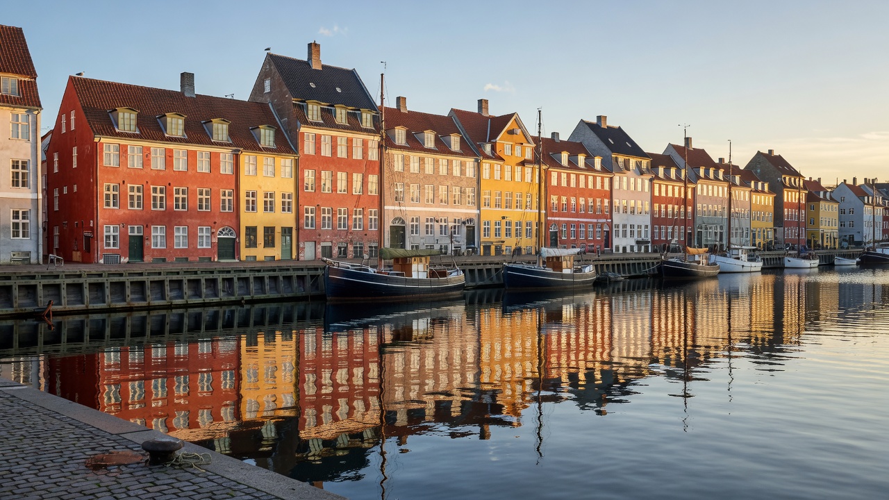 Copenhagen waterfront with historic quayside buildings reflected in the harbour