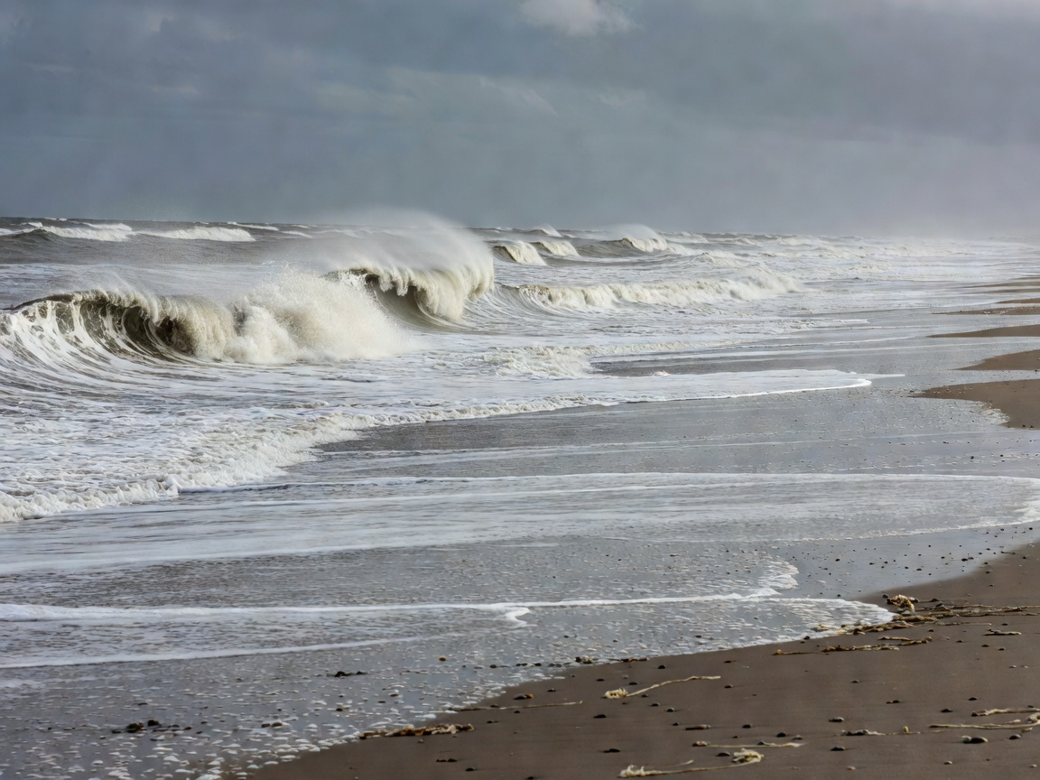 North Sea waves rolling onto a wide exposed beach
