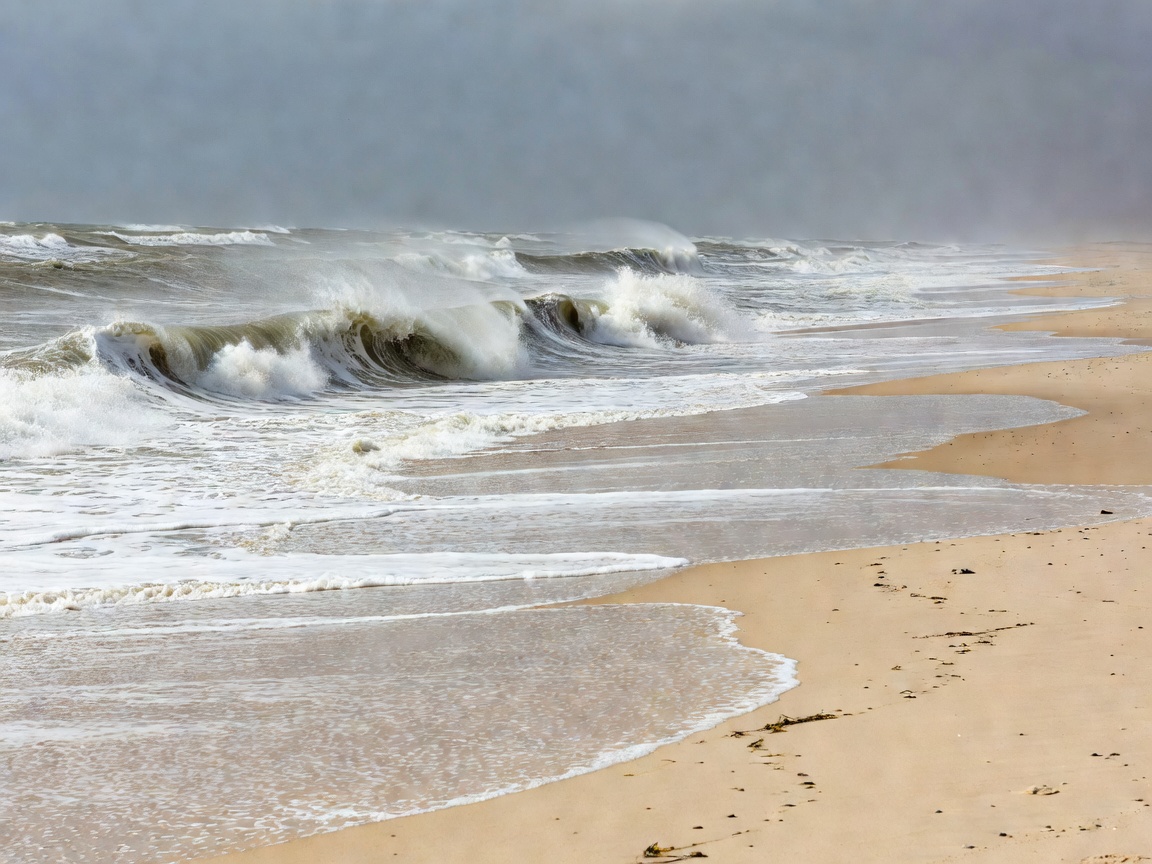 Open North Sea waves breaking on a wide exposed sandy beach