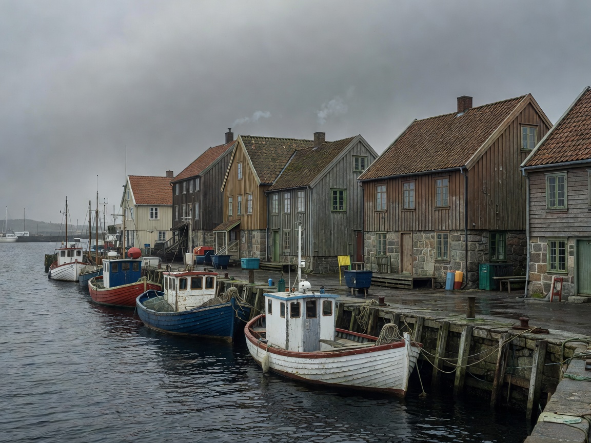 Small fishing boats moored in a northern European harbour beside quayside buildings