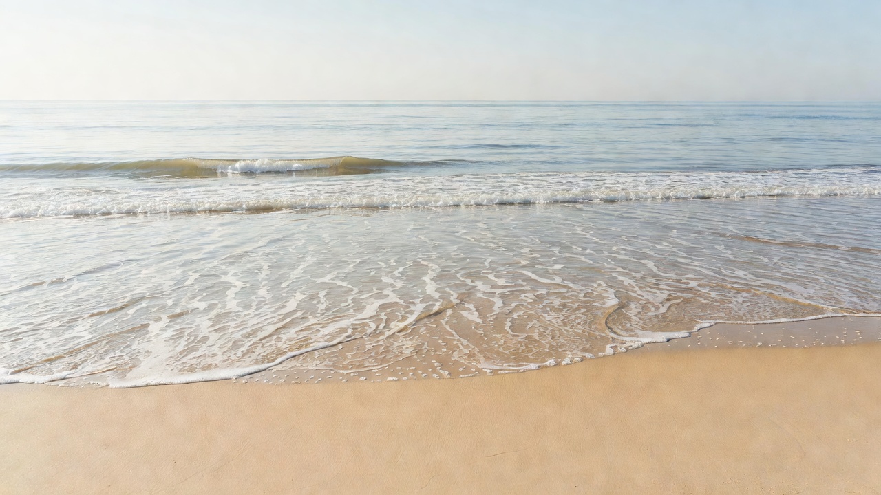 Waves breaking gently on an open sandy shoreline